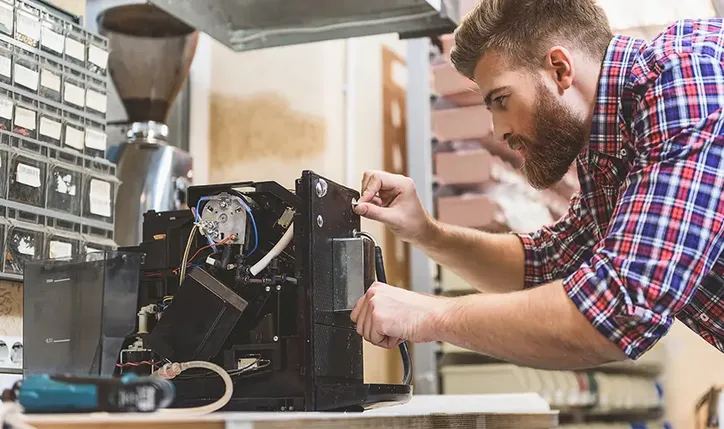 Mężczyzna naprawiający ekspres do kawy